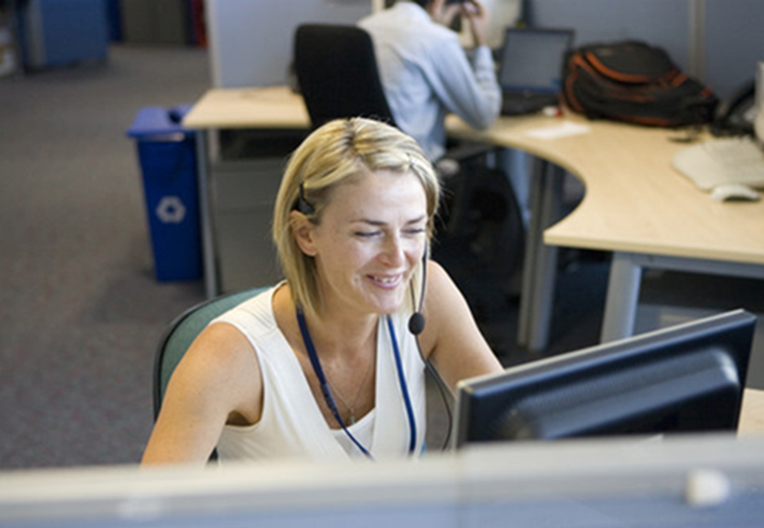 Woman at her desk on call