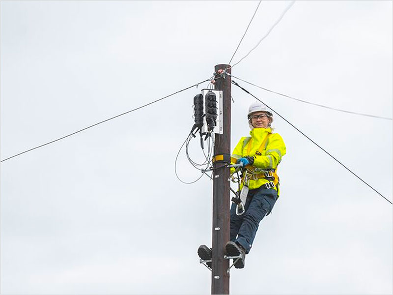 Openreach engineer climbing a telegraph pole to install fibre to the cabinet broadband infrastructure