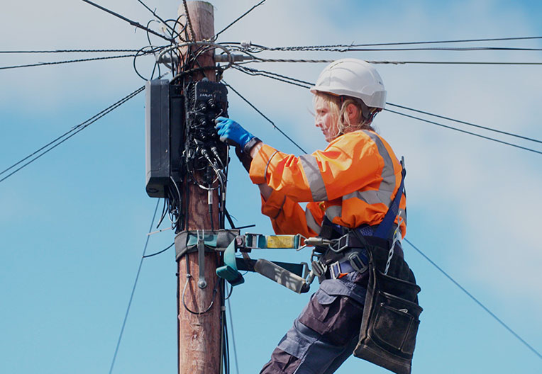 Engineer running fibre from a pole